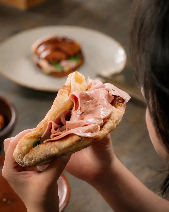 A guest holding flatbread with mortadella, Shaffa GastroBazar, Balangan, Bukit