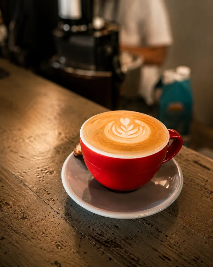 A latte in a red cup at the bar, coffee in Uluwatu at Shaffa GastroBazar